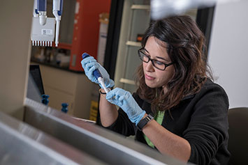 Woman holding a pipette. Link to Gifts of Real Estate